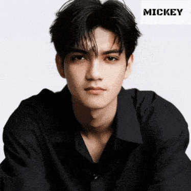 a young man in a black shirt with the name mickey on the bottom right