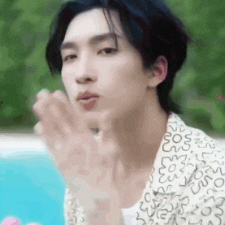 a close up of a person blowing a kiss with their hands .