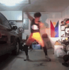 a person is dancing in a garage in front of a car