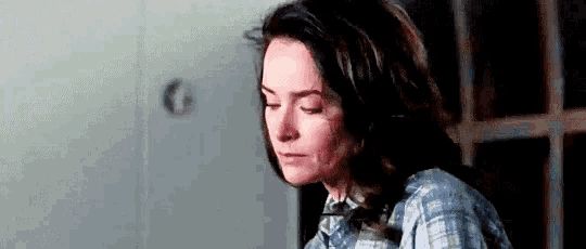 a woman is sitting in front of a window with her eyes closed and looking down .