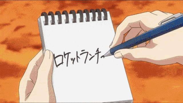 a person is writing in a notebook with chinese writing