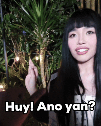 a woman with long black hair is holding a string of lights and says huy ano yan ?