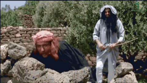 two men are standing next to each other and one is holding a sword