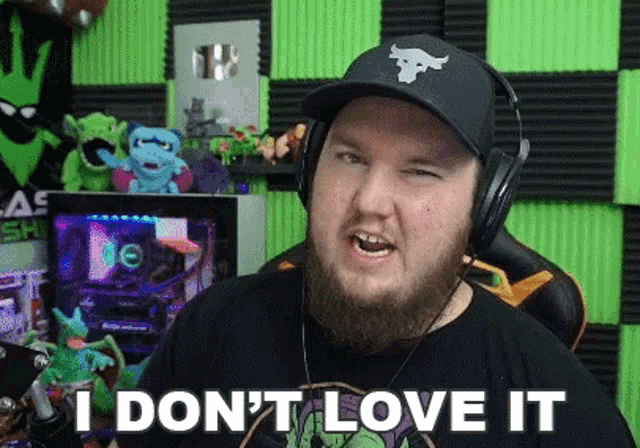 a man with a beard wearing headphones and a hat says i don 't love it