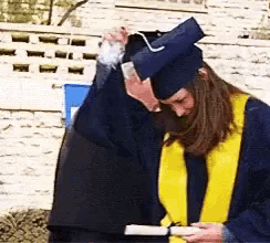 a woman in a graduation cap and gown is holding her head