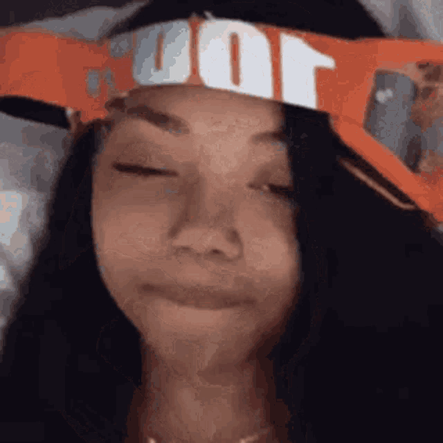 a woman wearing a headband with the word nike on it is making a face .