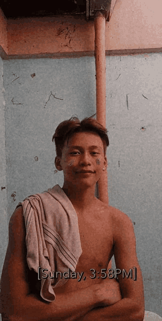 a shirtless man with a towel around his neck is standing in front of a wall with the time sunday 3:58 pm