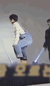 a man in overalls is squatting on a stage in front of a sign that says 916