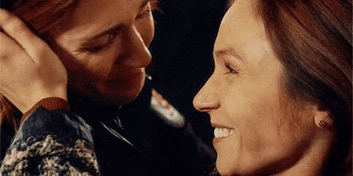 a close up of two women touching each other 's faces .