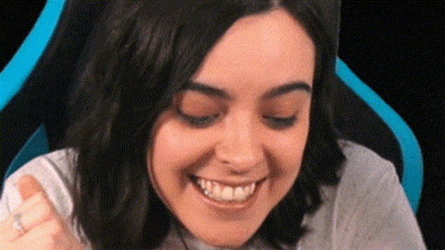 a close up of a woman 's face with her eyes closed and a ring on her finger .