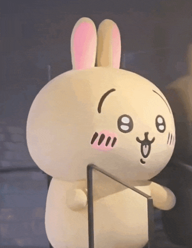 a stuffed bunny with pink ears is standing next to a glass railing