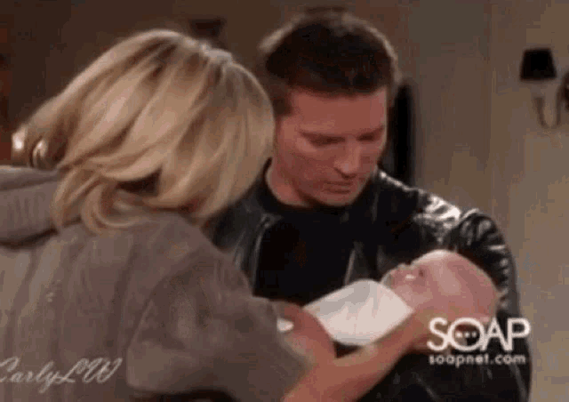 a man and a woman are holding a baby .