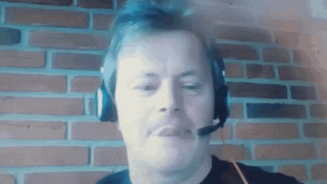 a man wearing headphones and a microphone looks at the camera