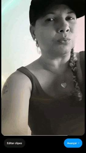 a black and white photo of a woman wearing a hat and braid