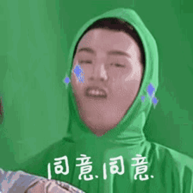 a man in a green hoodie is making a funny face