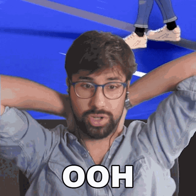 a man with glasses and a beard has the word ooh on his shirt