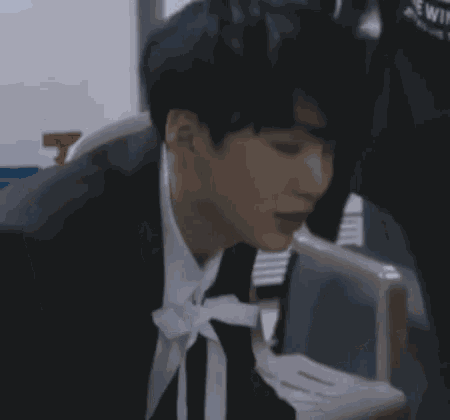 a man in a suit and tie is sitting in a chair with his eyes closed .