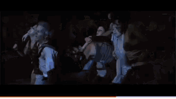 a group of people are dancing in a dark room with a red border around the bottom