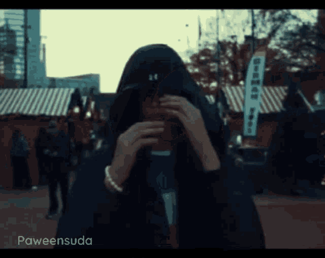 a person wearing a hooded jacket has the name paweensuda on the bottom