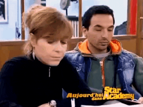 a man and a woman are sitting in front of a sign that says star academy ..