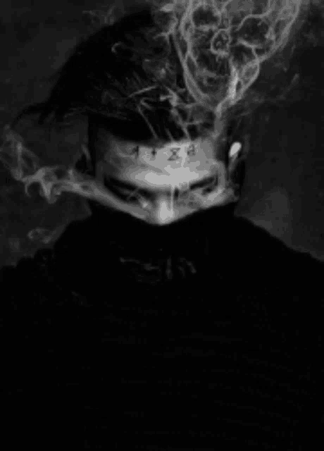 a black and white photo of a man smoking a cigarette .