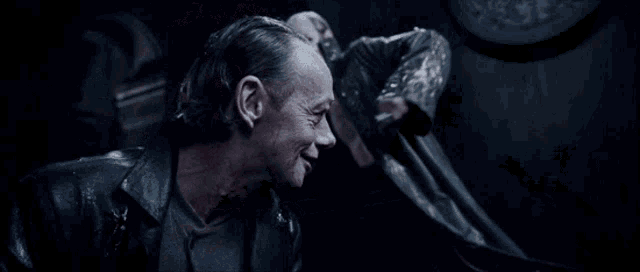 a blurry picture of two men in a dark room .