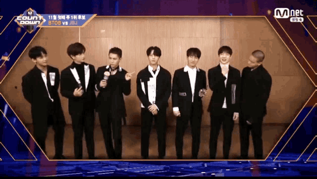 a group of young men are standing in front of a screen that says mnet