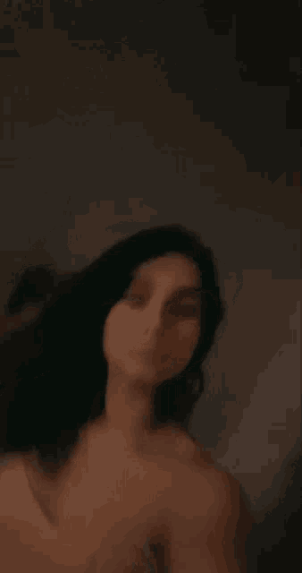 a blurry picture of a naked woman taking a selfie in the dark .