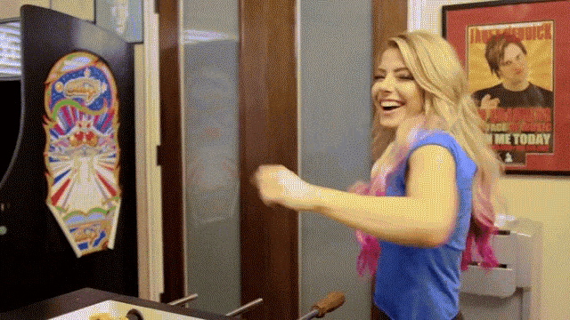 a woman in a blue shirt is dancing in front of a poster that says ' tomorrow '