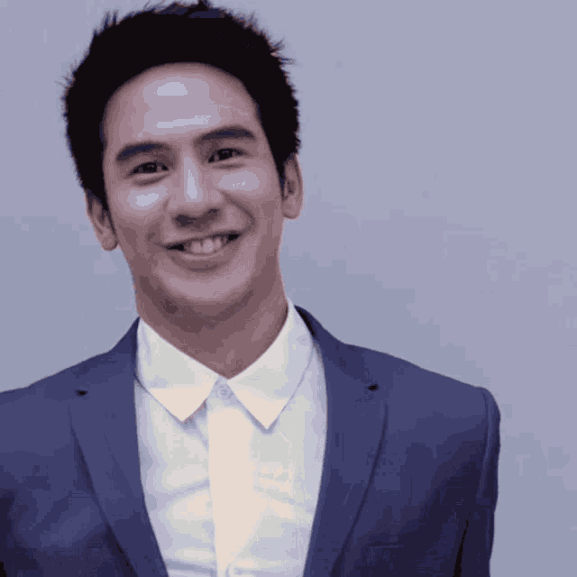 a man in a suit and white shirt is smiling