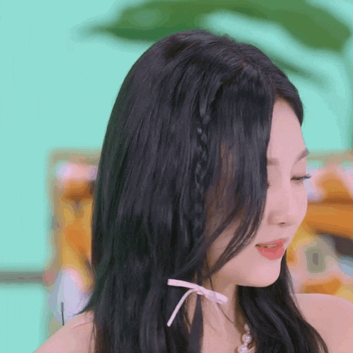 a close up of a woman 's hair with a braid and a pink bow