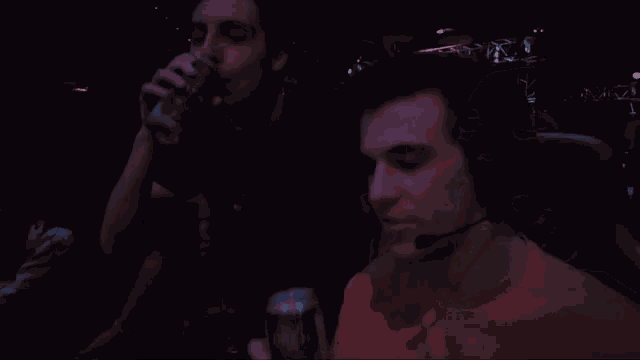 a man wearing a headset is drinking a can of soda