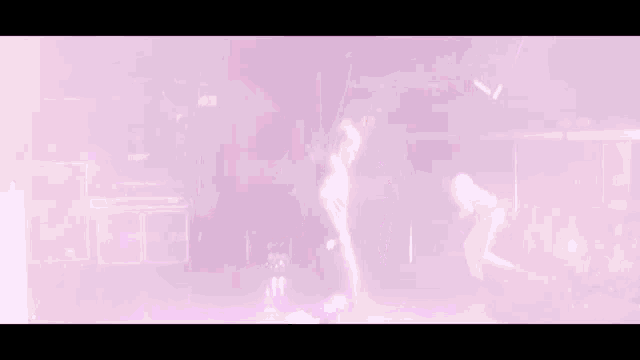 a man and a woman are dancing on a stage with purple lights behind them
