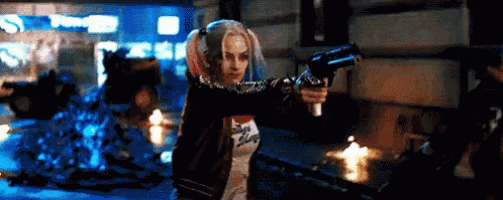 harley quinn from suicide squad is holding a gun in a pixelated image .