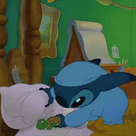a cartoon character named stitch is laying on a bed