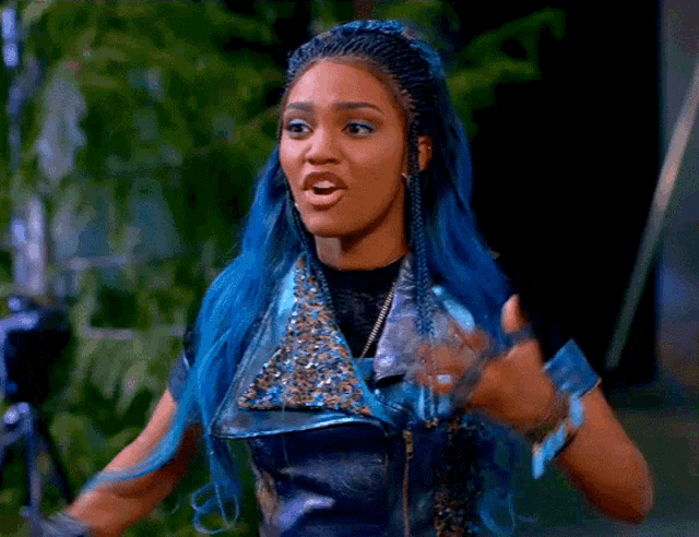 a woman with blue hair and braids is wearing a leather jacket