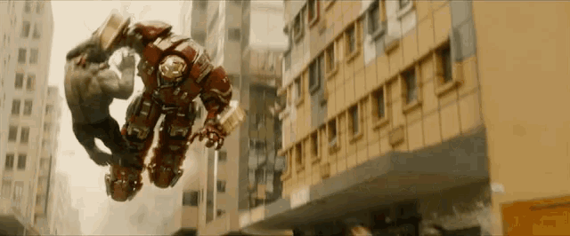 a hulk and a hulk buster are fighting in the air