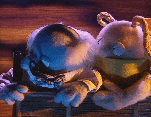 two stuffed animals are sitting next to each other and one is wearing glasses