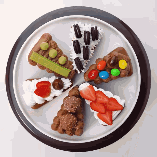 a white plate topped with a variety of desserts including kitkat