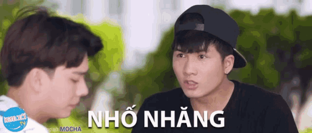 two young men are standing next to each other and the words nho nhưng are on the bottom right
