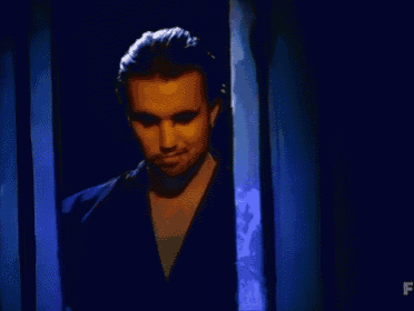a man with glowing eyes is standing in a doorway with the letter f visible in the corner