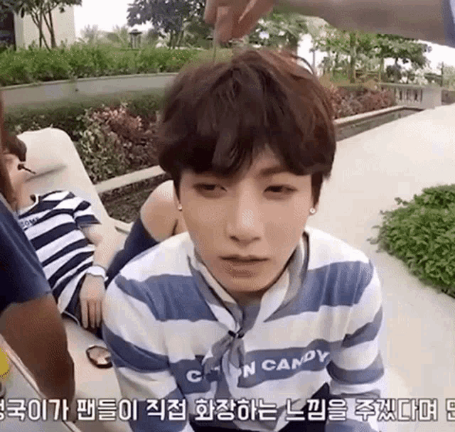 a young man wearing a striped shirt that says candy