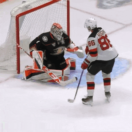 a hockey player with the number 86 on his jersey stands in front of a goalie