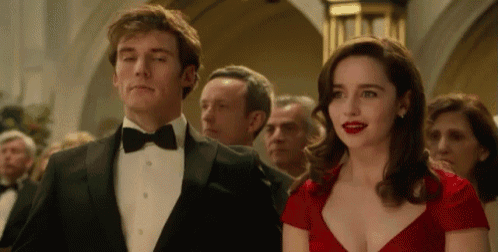 a man in a tuxedo and a woman in a red dress are standing next to each other at a party .