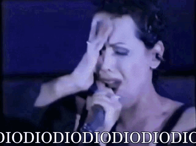 a woman is crying while singing into a microphone with the words diodiodiodiodiodiodi on the bottom
