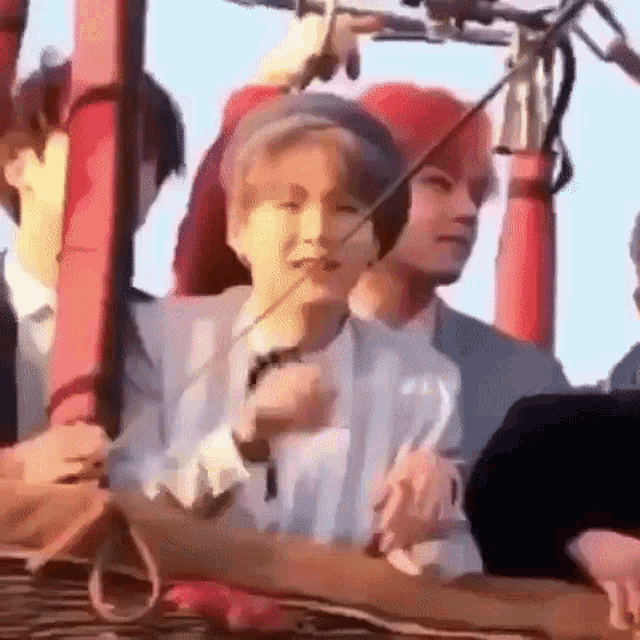 a group of people are sitting in a hot air balloon and one of them is holding a microphone .