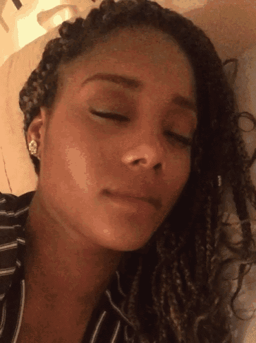 a close up of a woman 's face with her eyes closed and earrings on