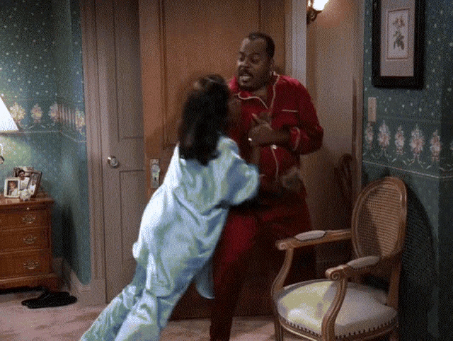 a man and a woman are fighting in a room