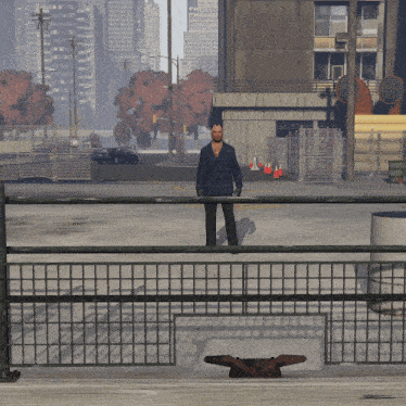 a man in a plaid jacket stands behind a fence