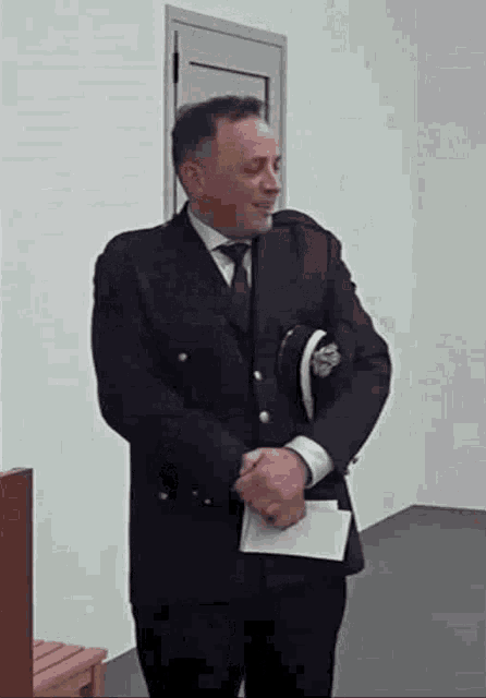 a man in a suit and tie is standing in front of a door .